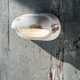 Antikolt felületű mázas kerámiából és bordázott üvegből készült kézműves falilámpa.